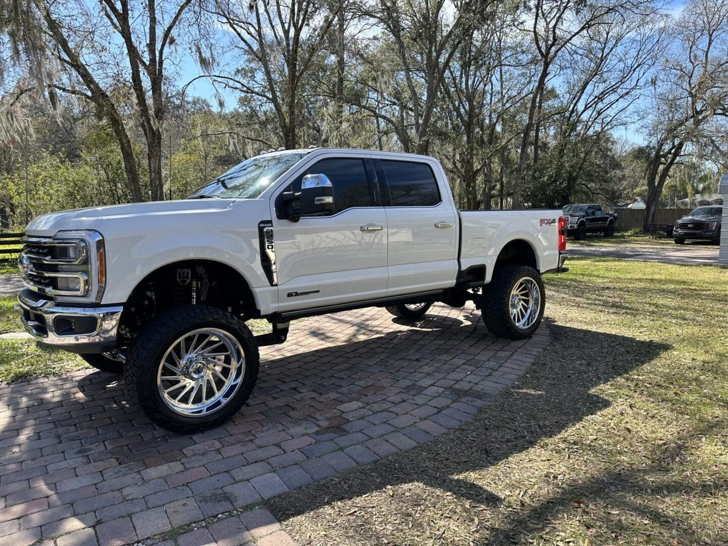 A white truck parked on top of a brick road.