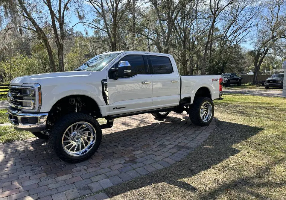 A white truck parked on top of a brick road.